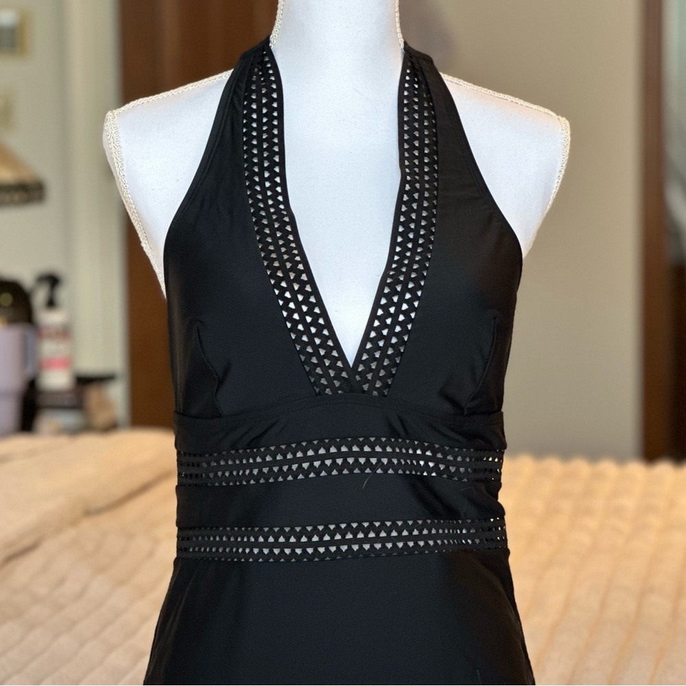 Black one piece swimsuit with eyelet cutouts. Halter & mid-back tie closures